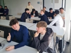 Schüler:innen sitzen in Gruppen an Arbeitstischen